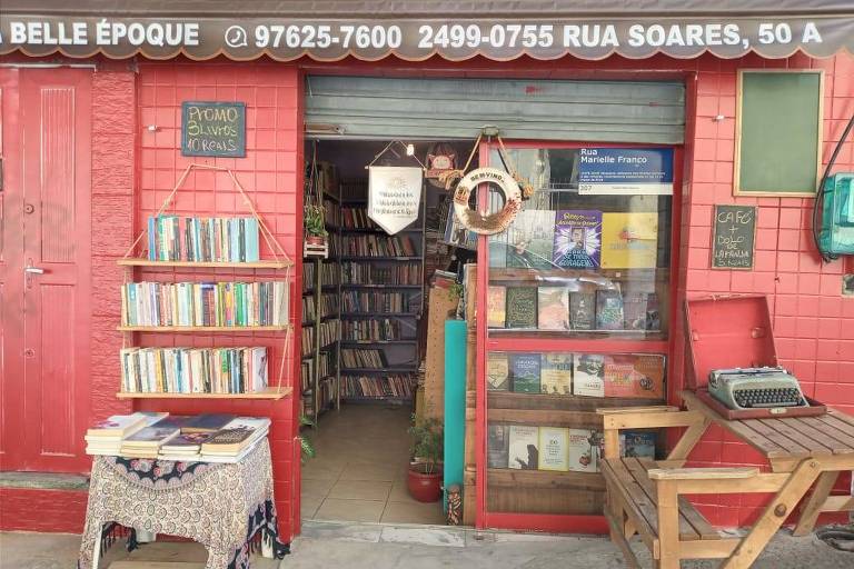 A imagem colorida mostra estantes de livros na frente de uma livraria