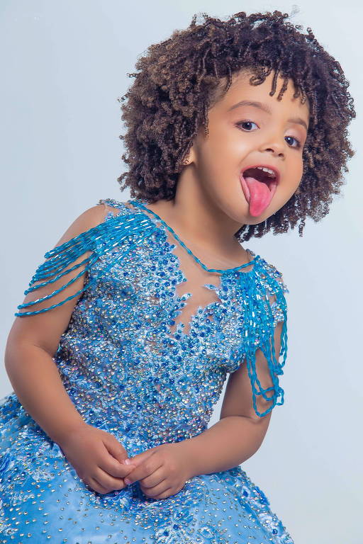 Menina bonita de 5 anos com cabelos escuros em um maiô azul de