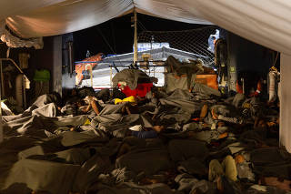 Migrants sleep on deck of a rescue ship Sea-Watch 3 after having been rescued in the Mediterranean Sea