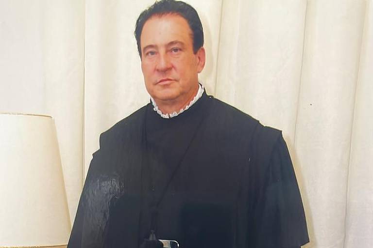 Imagem em primeiro plano mostra homem posando para foto vestido com toga 
