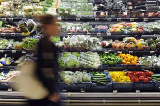 File photo of a customer walking past the fruit and vegetable section of a Carrefour grocery store in Brussels