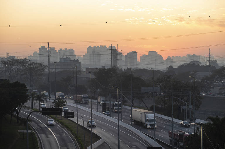 Vista do amanhecer na cidade de São Paulo com a marginal Tietê em destaque e prédios ao fundo