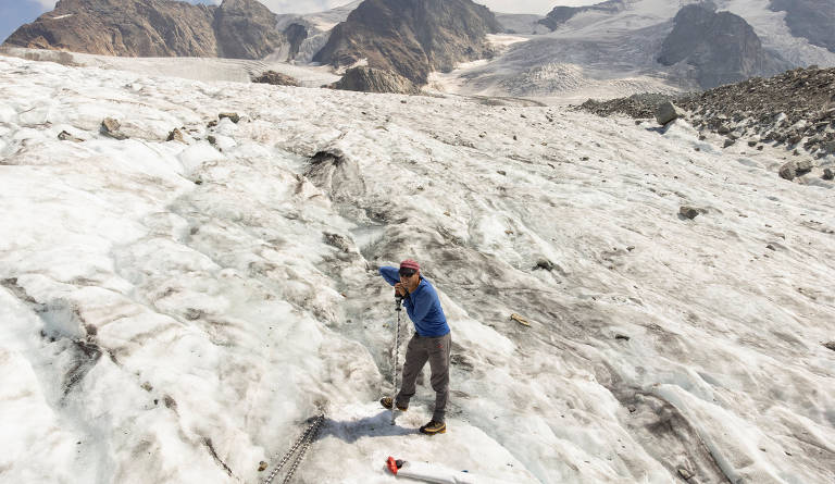 Glaciologista Andreas Linsbauer fura um buraco em um ponto de medição da neve acumulada na geleira Pers, próximo do resort alpino de Pontresina, na Suíça
