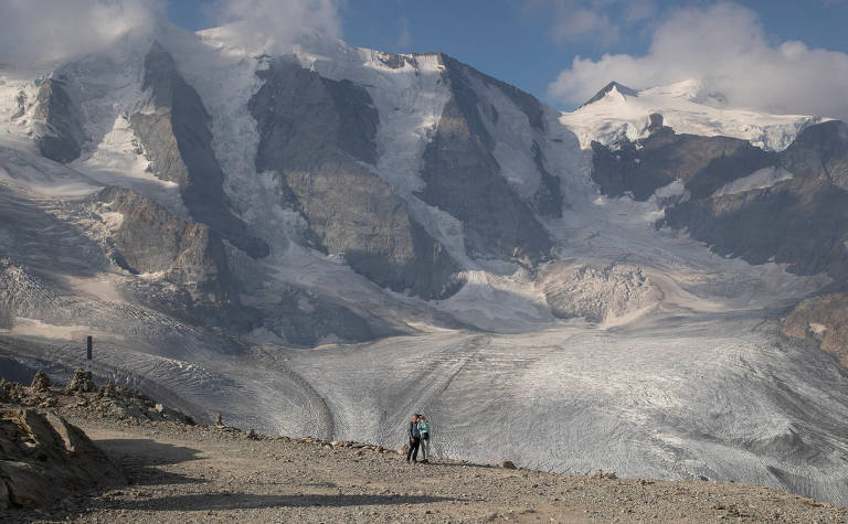 Casal tira selfie na geleira Pers, perto do resort alpino de Pontresina, na Suíça; a maioria das geleiras do mundo remanescentes da última era glacial estão recuando devido às mudanças climáticas