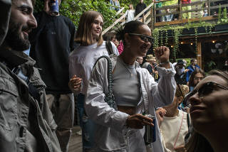 Young people partying in Kyiv on July 17, 2022. (Laura Boushnak/The New York Times)