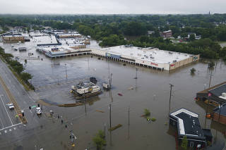 A flooded road and shopping area near Coldwater Creek in Florissant, Mo., July 26, 2022. (Michael B. Thomas/The New York Times)