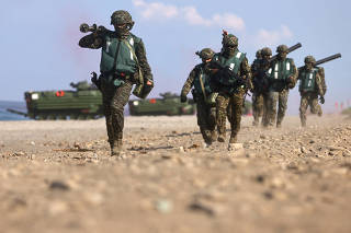 Soldiers exit from AAV7 amphibious assault vehicle run to position during an Amphibious landing drill as part of the Han Kuang military exercise
