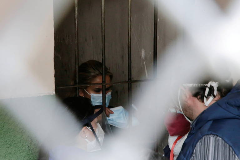 Com máscara de proteção contra a Covid, a ex-presidente interina da Bolívia, Jeanine Áñez, está atrás das grades em uma prisão de La Paz