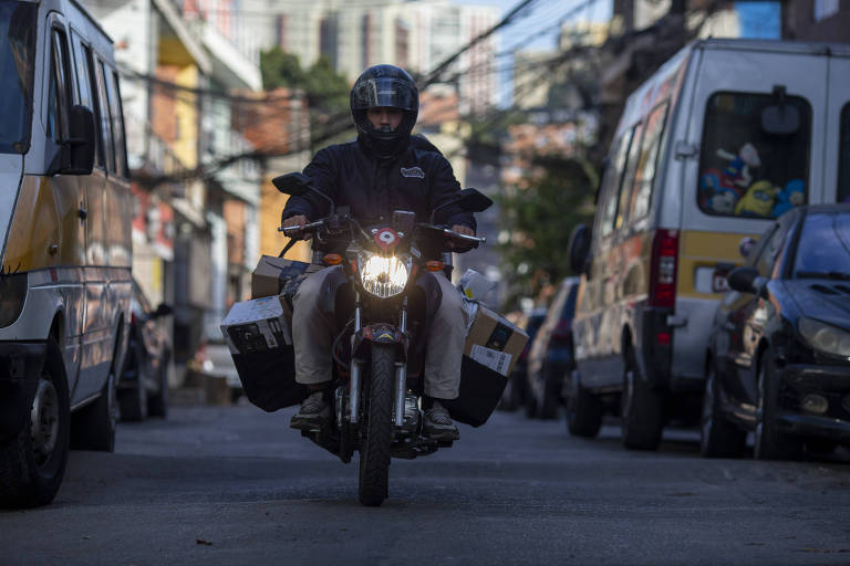 Entregador da Favela Llog transporta de moto encomendas de moradores feitas na Amazon pelas ruas de Paraisópolis