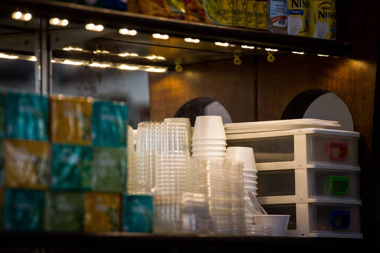 Imagem mostra copos de plásticos empilhados ao lado de caixas de chá.