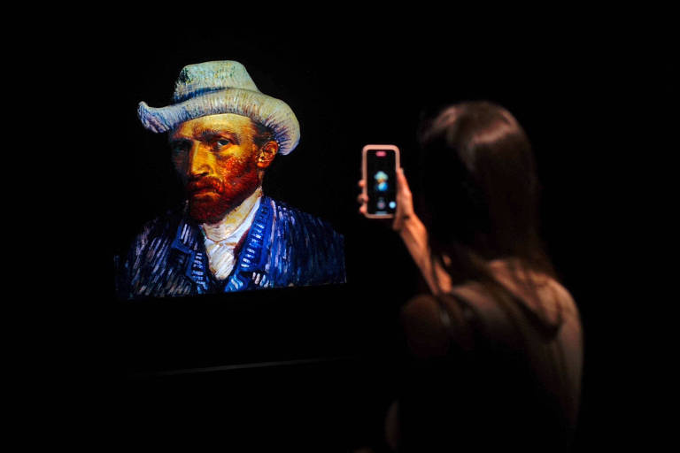 Mulher tira foto com seu celular do famoso AutoRetrato de Vincent Van Gogh