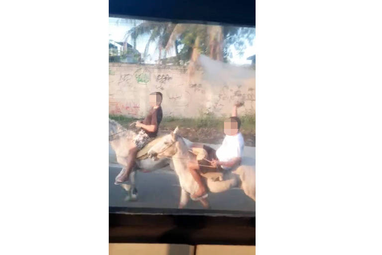 dois adolescentes em cavalos com rostos borrados filmados do lado de fora de um ônibus