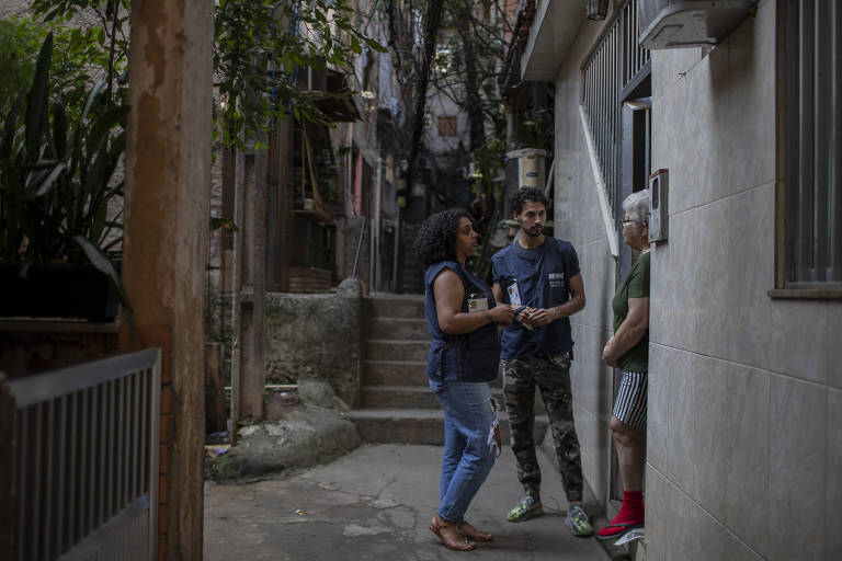 Recenseadores conversam com moradora na favela da Rocinha, no Rio, no primeiro dia de coleta dos dados do Censo 