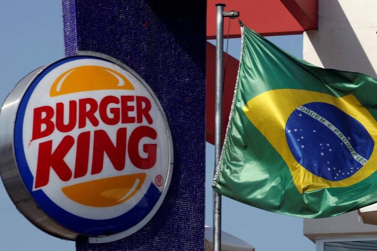 Logotipo do Burger King perto da banderia brasileira em uma loja da rede em São Paulo