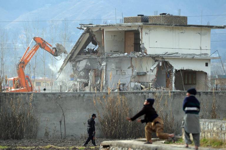 Garotos paquistaneses brincam perto de demolição do complexo onde o líder da Al Qaeda Osama bin Laden foi morto, em Abbottabad, no Paquistão