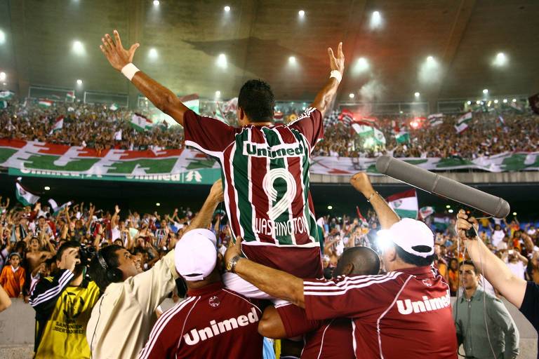 Carregado por torcedores e com os braços erguidos, o atacante Washington, que usa a camisa número 9, comemora no Maracanã a vitória do Fluminense sobre o São Paulo em mata-mata das quartas de final da Libertadores de 2008