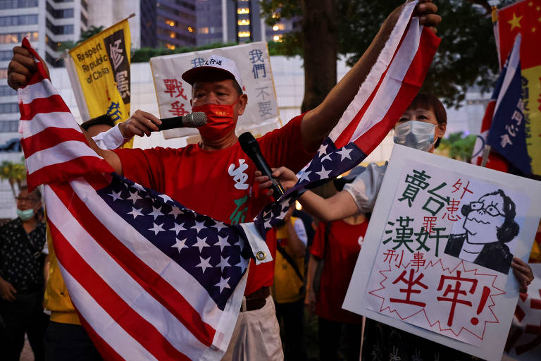 Manifestante rasga bandeira dos EUA durante protesto contra a visita de Nancy Pelosi, em Taipé, capital de Taiwan