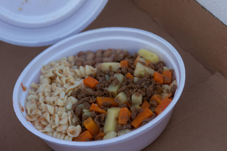 Imagem mostra quentinha de isopor com arroz, feijão, legumes, carne moída e macarrão.