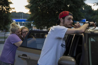 Madison Underwood, center, hugs her mother, Jennifer Underwood, while her fiance, Adam Queen, takes a break after the pre-dawn four-hour drive across state lines and time zones to a Georgia abortion clinic, in Atlanta, July 8, 2022. (Kendrick Brinson/The New York Times)