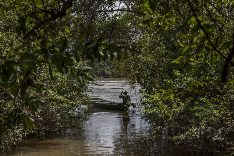 Indígena da vila do Boqueirão, em Boa Vista, navega pelo rio Uraricoera, cuja água está contaminada pelo mercúrio usado na mineração ilegal
