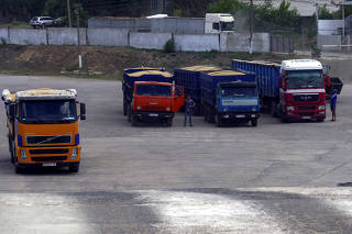 Truck drivers wait in queue to unload barley grain at a grind terminal in Odesa Region