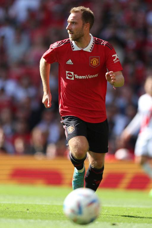 O dinamarquês Eriksen, do Manchester United, avança com a bola no amistoso do time contra o Rayo Vallecano no estádio Old Trafford; ele veste camisa vermelha e calção preto