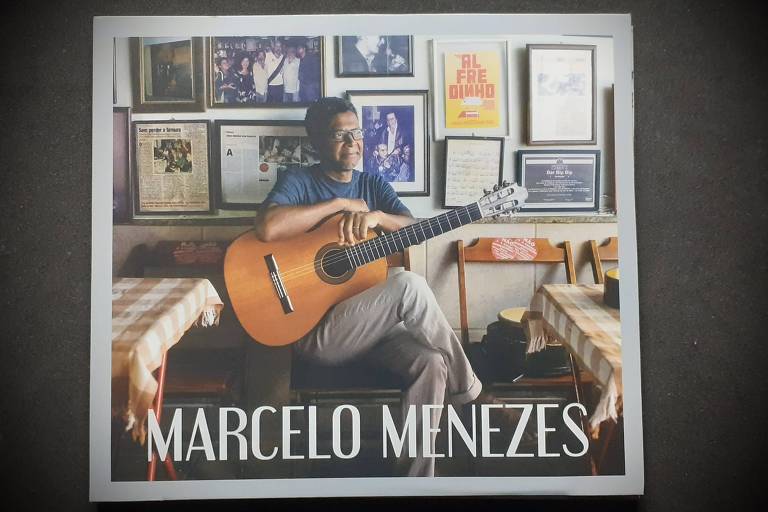 Em foto colorida, a capa do álbum 'Marcelo Menezes' traz o autor aparece com o violão no colo