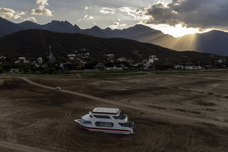A tourist boat grounded in a reservoir in La Boca, on the outskirts of Monterrey, Mexico, on June 20, 2022. (Cesar Rodriguez/The New York Times)