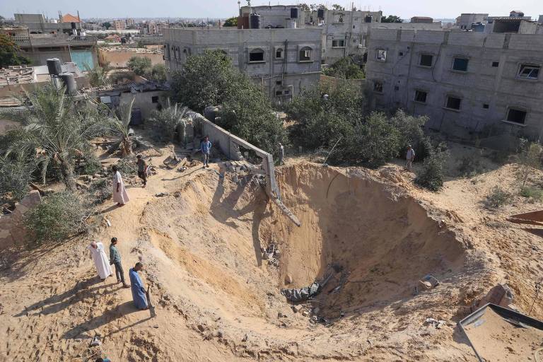 Palestinos à beira de cratera olham para dentro de buraco