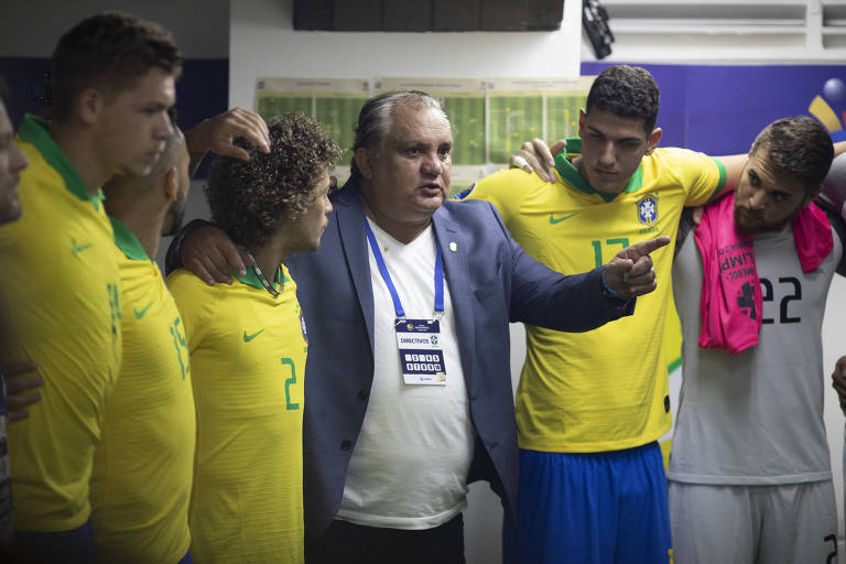 Branco, no centro e de camisa branca, fala com jogadores da seleção brasileira de base