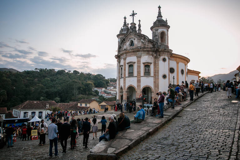 Público acompanha o festival Tudo É Jazz no palco do Largo do Rosário, em Ouro Preto, com uma igreja no pé de uma ladeira