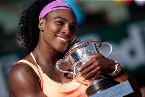 (FILES) In this file photograph taken on June 6, 2015, US Serena Williams celebrates with the trophy following her victory over Czech Republic's Lucie Safarova after the women's singles final match of the Roland Garros 2015 French Tennis Open in Paris. - US tennis great Serena Williams announced on August 9, 2022, that 