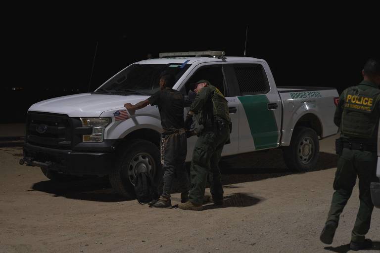 Oficial da patrulha de fronteira dos Estados Unidos prende um homem após ele atravessar a fronteira saindo do México e chegando à cidade de Yuma, no Arizona; grande parte dos migrantes ilegais são presos e depois deportados