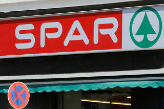 FILE PHOTO: The logo of Austrian supermarket chain Spar is seen behind a traffic sign at a shop in Vienna