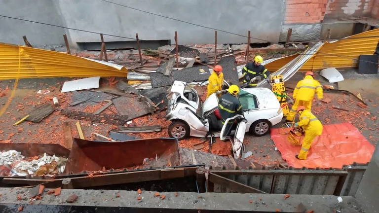 Bombeiros retiram carro destruído por queda de estruturas provocada pelo ciclone extratropical que atingiu Santa Catarina nesta quarta-feira (10); moradores precisaram deixar suas residências para evitar desabamentos e destelhamentos
