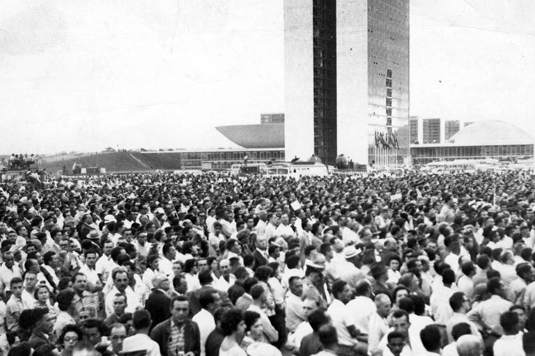 na foto em preto e branco, uma multidão se aglomera em frente ao prédio do congresso nacional