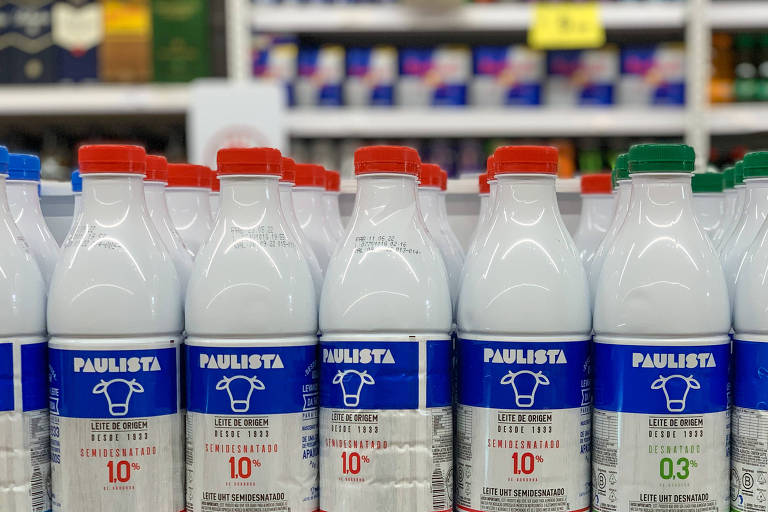Fotografia colorida mostra prateleira de supermercado com diversas embalagens de leite. 