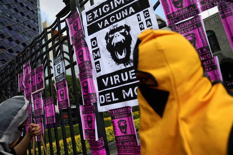 Manifestantes colam cartazes com imagem de macacos