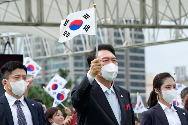 O presidente sul-coreano Yoon Suk-yeol, agita bandeira do país em Seul, durante cerimônia para comemorar o Dia da Libertação da Coreia do domínio colonial japonês, em 1945