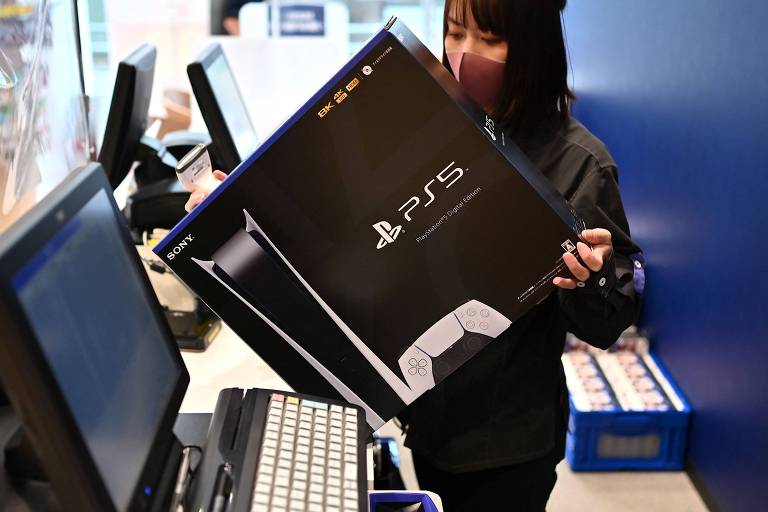 Vendedora carrega console PlayStation 5 recém comprado em Kawasaki, no Japão