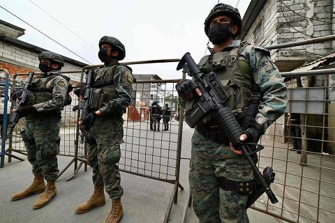 Ecuadorian soldiers guard the site of an explosion in Cristo del Consuelo neighborhood in Guayaquil, Ecuador, on August 15, 2022. - An explosion attributed to organized crime in Ecuador left five dead this Sunday and forced the President Guillermo Lasso to declare a state of emergency in the coastal city of Guayaquil, one of the most affected by crime linked to drug trafficking. (Photo by Marcos Pin / AFP)