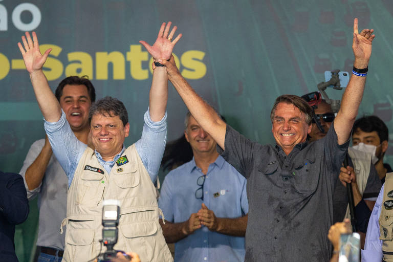 Jair Bolsonaro levanta a mão de Tarcísio de Freitas em evento da concessão da via Dutra