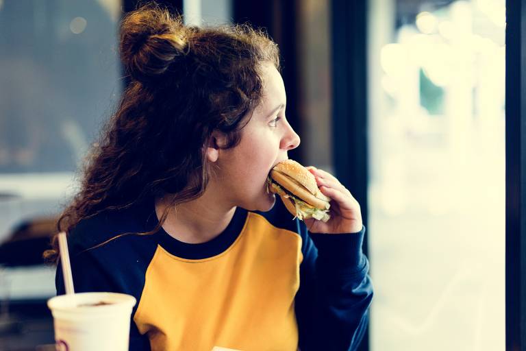 Menina comendo hambúrguer