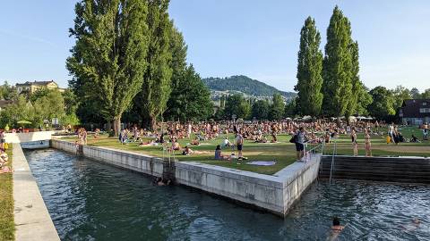Pessoas lotam o parque Marzili, à beira do rio Aare, em Berna (Suíça)