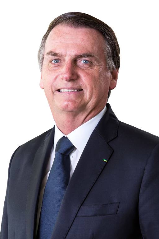 Presidente Jair Bolsonaro de terno e gravata sorri