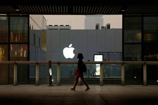 FILE PHOTO: A woman walks past an Apple store in Beijing