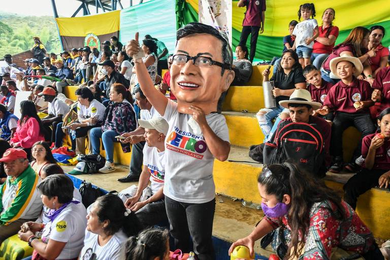 Apoiador de Gustavo Petro usa máscara com o rosto do presidente durante cerimônia na cidade colombiana de Suárez