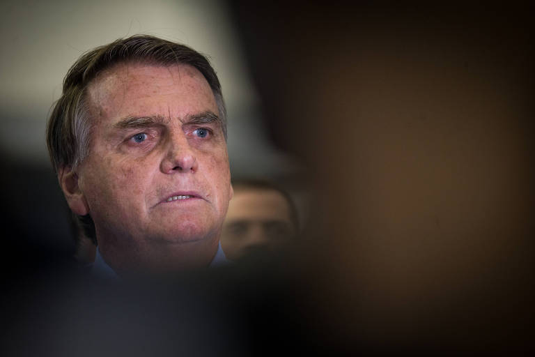 Rosto de Bolsonaro aparece atrás de sombra formada por pessoa em primeiro plano
