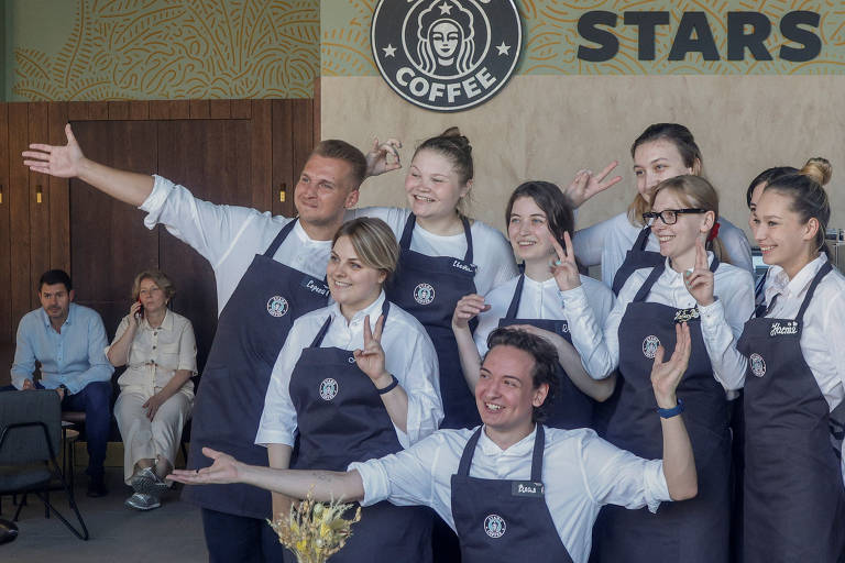 Funcionários posam para fotos no lançamento da cafeteria Stars Coffee, que foi inaugurada no dia 19 de agosto de 2022