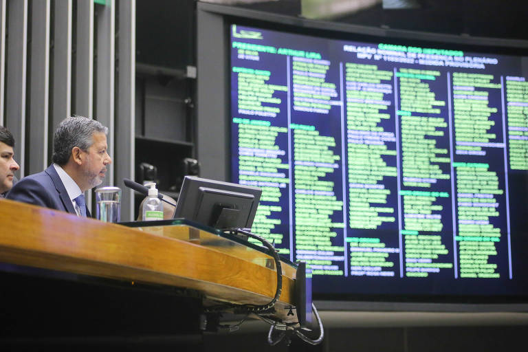 imagem mostra o presidente da Câmara dos Deputados, Arthur Lira, com o painel de votações no fundo